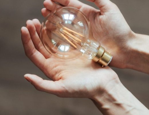 a lighted bulb sitting in female hands